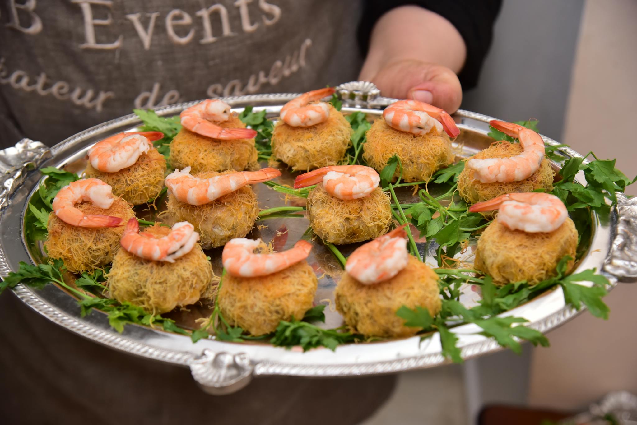 Delicious shrimp appetizers served elegantly on a silver platter with fresh greens.